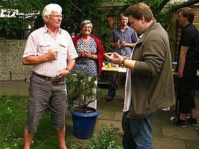 Jason unterhält sich mit Gästen im Garten